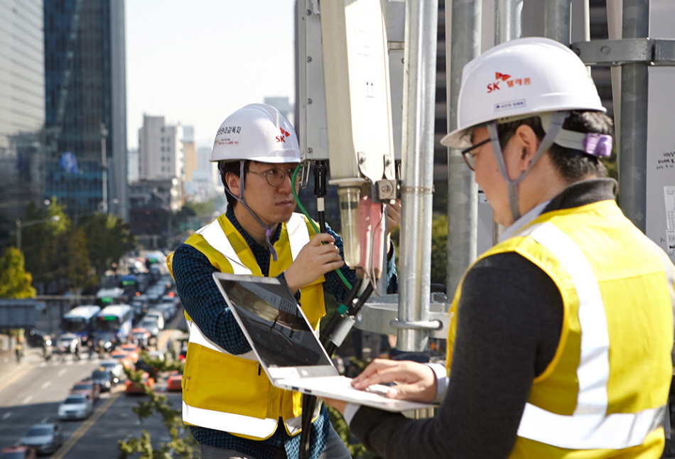 SK텔레콤 5G연구원들이 서울 명동의 건물 옥상에 설치된 5G 기지국에서 LTE-5G 장비 · 주파수 연동 결과를 측정하고 있다.