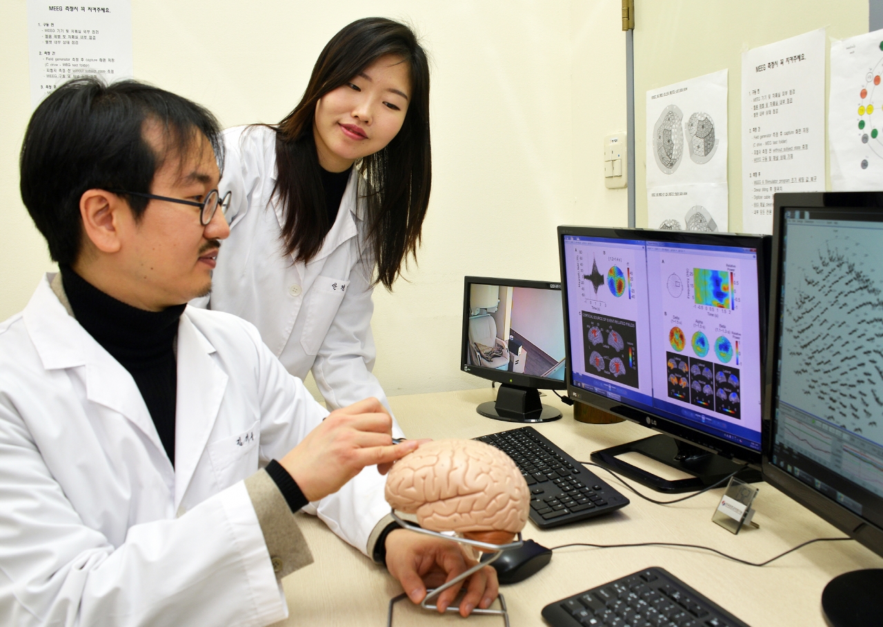 KRISS 김기웅 책임연구원(왼쪽) 연구진이 순수 온도자극에 대한 뇌자도 측정결과를 분석하고 있다.(사진:표준연)