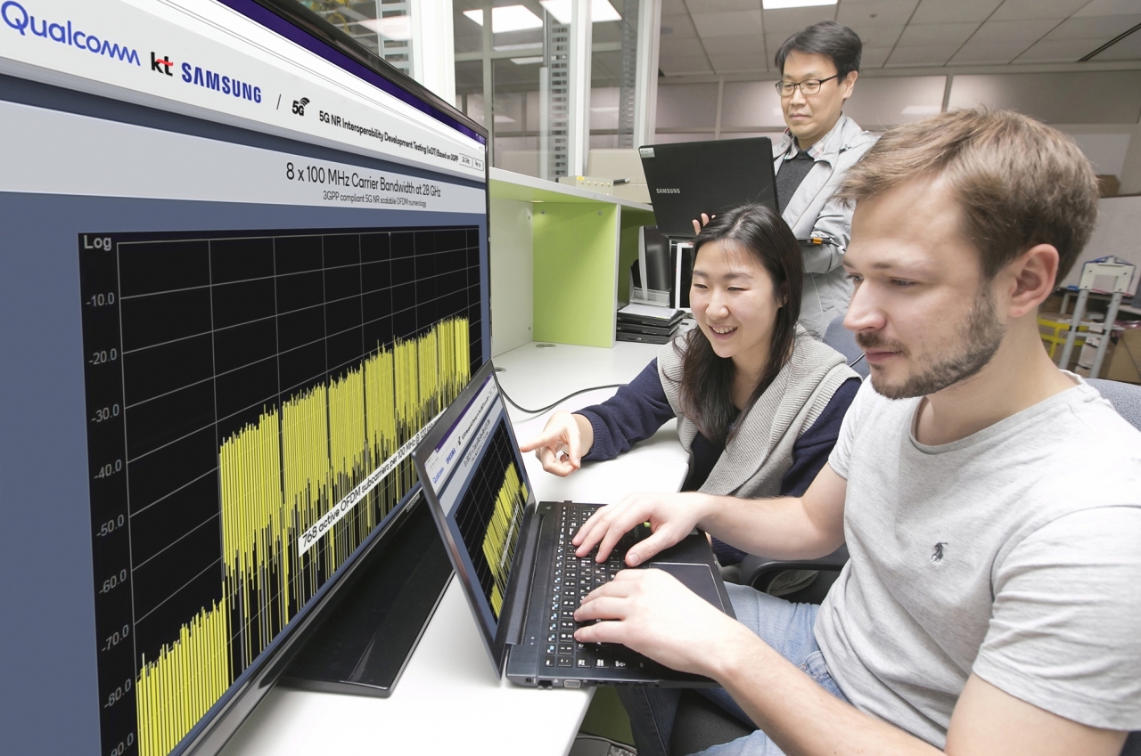 KT와 삼성전자, 퀄컴 직원들이 수원 삼성전자 연구소에서 5G 표준규격 기반으로 데이터 통신을 시연하고 있다.