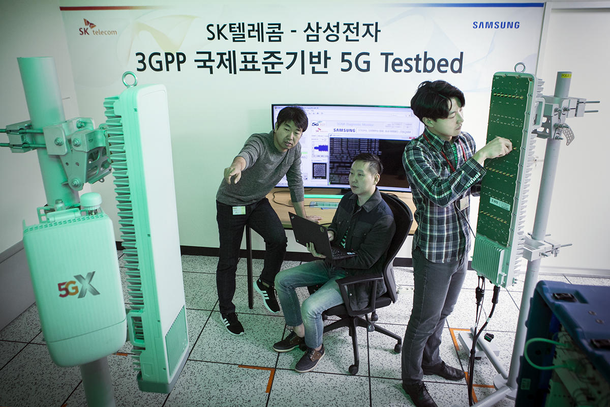 SK텔레콤과 삼성전자 연구원들이 15일 SK텔레콤 분당사옥 5G 테스트베드에서 3.5GHz 대역 5G상용 장비로 퍼스트콜(First call)에 성공했다.(사진:SKT)