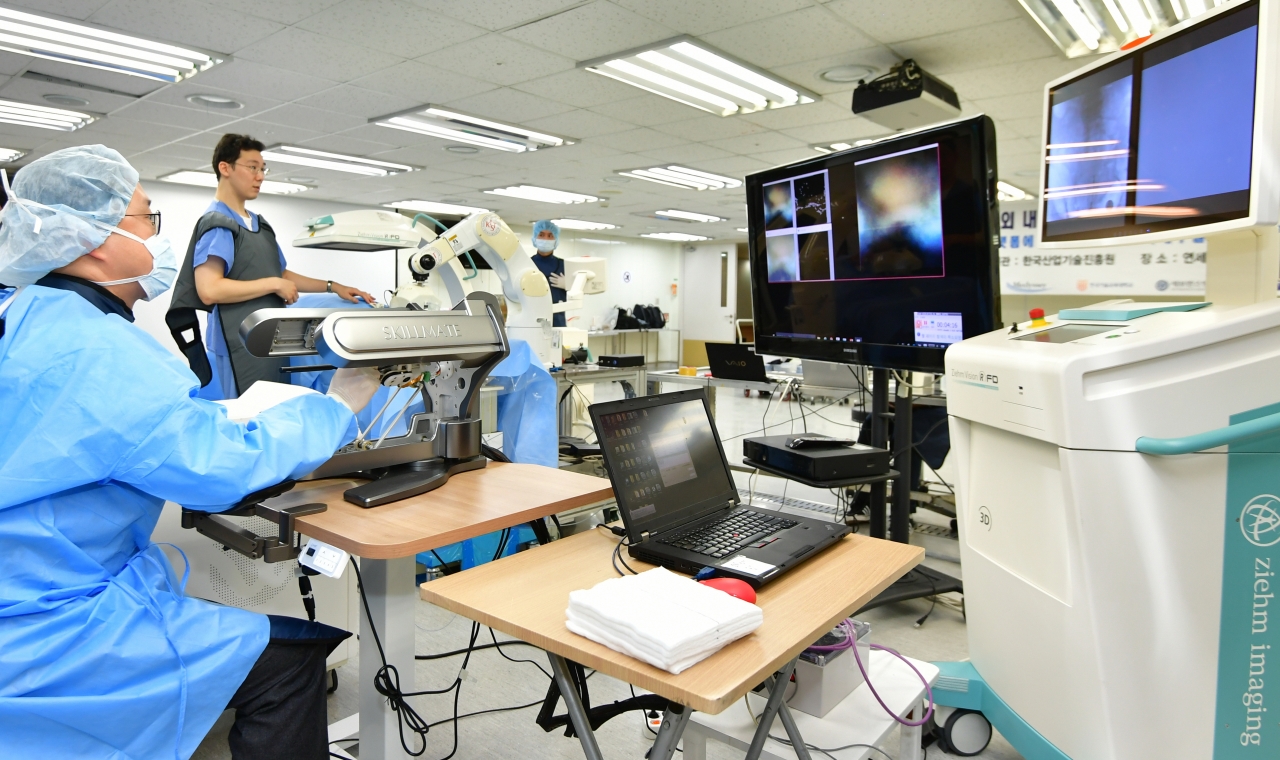 연세대학교 신동아 교수가  '닥터 허준(Dr. hujoon)' 로봇시스템으로 카테터를 원격으로 조종하고 있다(사진:KIST)