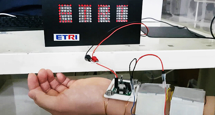 배터리 없이 사람의 체온만으로 실제 LED 전광판에‘ETRI’라는 글씨를 선명하게 점등