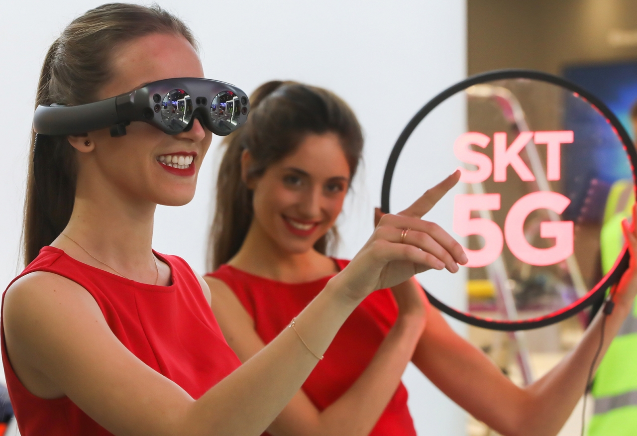 SK텔레콤 모델이 차세대 AR 글래스를 착용하고 5G 기술을 이용한 AR/VR 솔루션 'T 리얼'을 체험하고 있다(사진:SKT)
