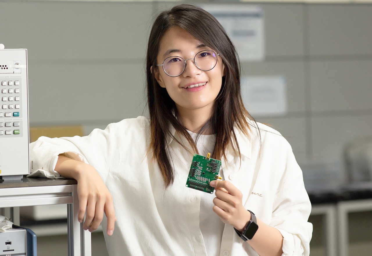 윤희인 UNIST 대학원생이 반도체 성능 측정실에서 반도체 칩을 손에 들고 서 있다