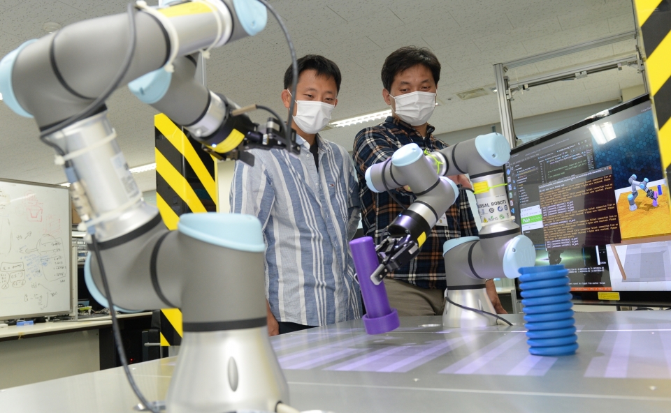 ETRI 연구진이 개발한 스마트팩토리용 로봇 자율지능 기술을 점검하는 모습(왼쪽부터 한효녕 선임연구원, 김현석 선임연구원)