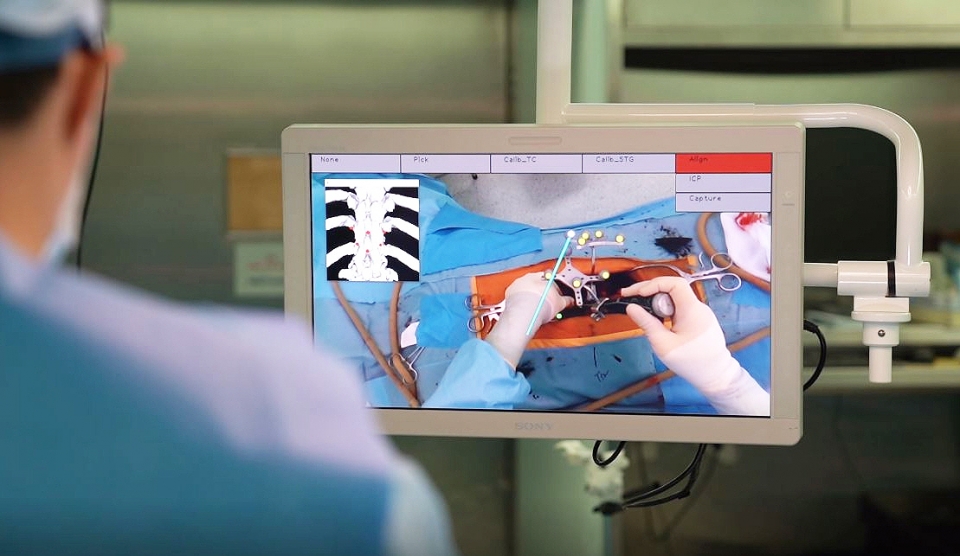 환자 수술 부위에 투영된 AR 기반 오버레이 그래픽으로 나사못이 들어갈 위치를 파악하고 있는 모습