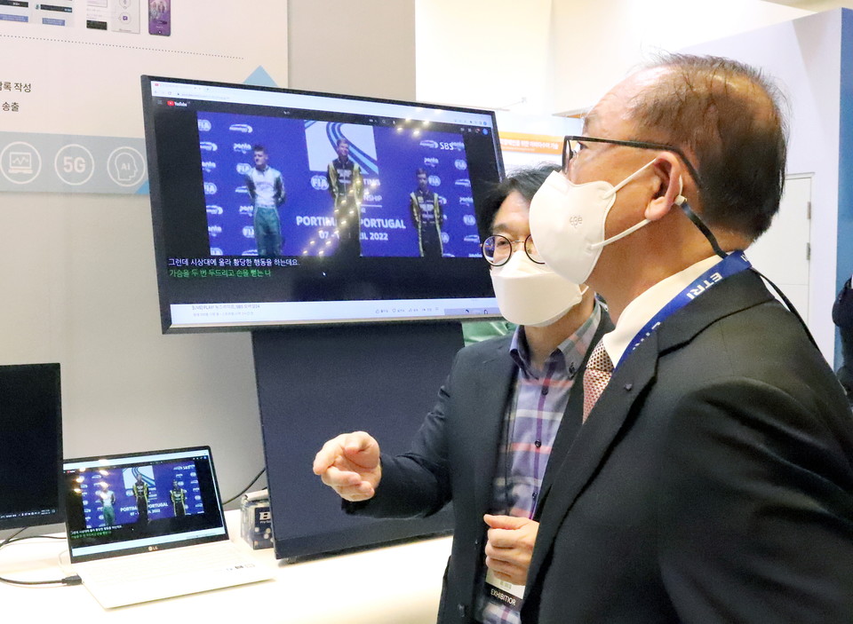김명준 원장이 ETRI  부스에서 AI 연구성과를 살펴보고 있는 모습(사진:본지)