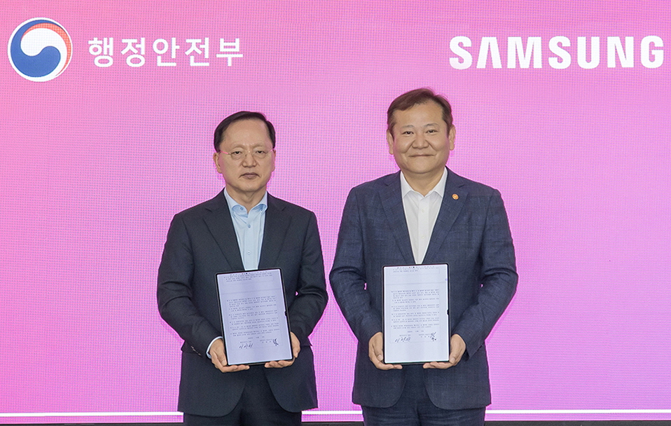 O Ministro da Administração Pública e Segurança, Lee Sang-min (foto à direita), e Park Hak-gyu, CEO do Samsung Electronics Management Support Office, tiram uma foto após assinarem o acordo comercial.